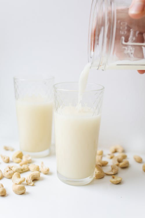 Free A Person Pouring Milk in the Glass Stock Photo