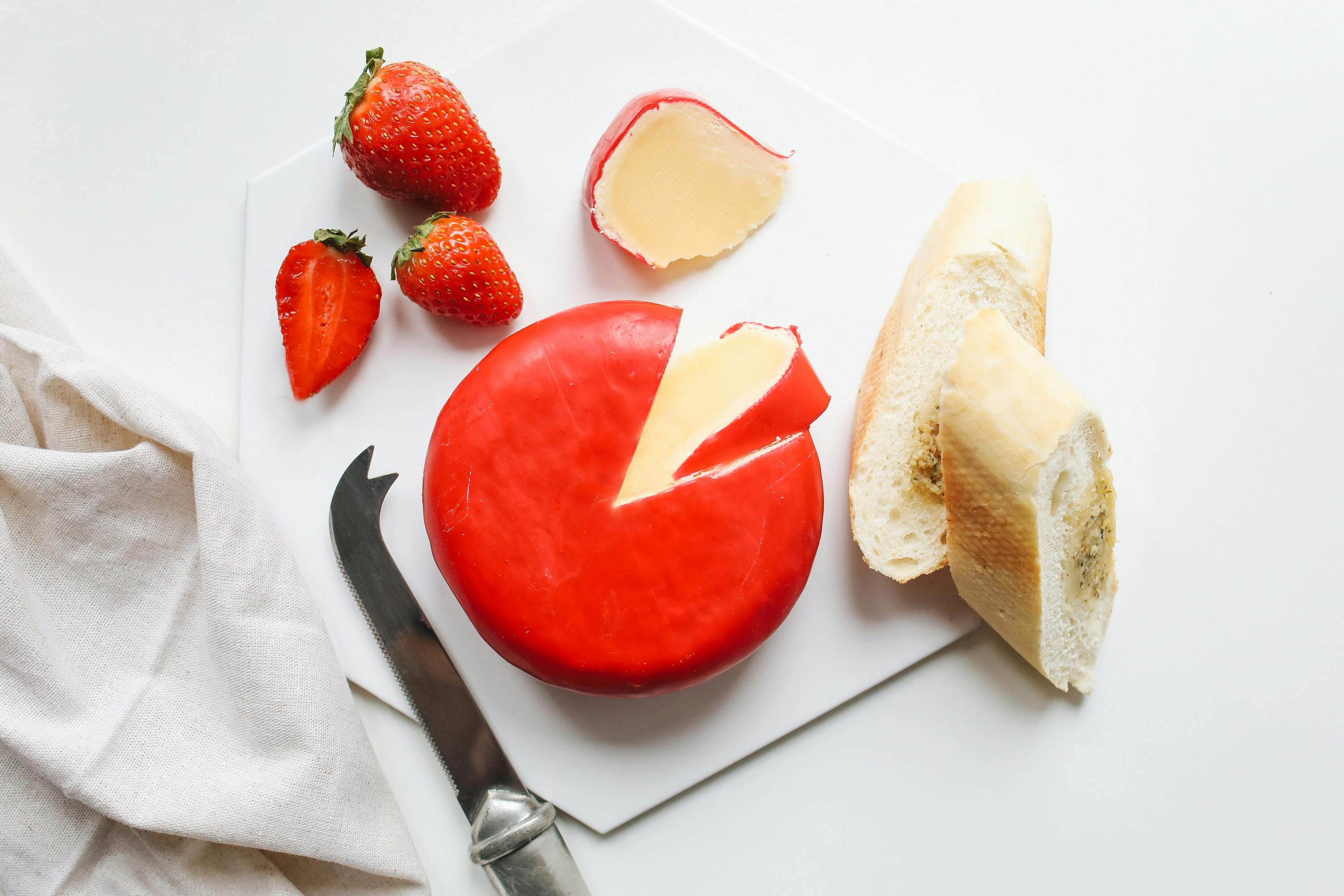 Cheese bread an strawberries on a platter.