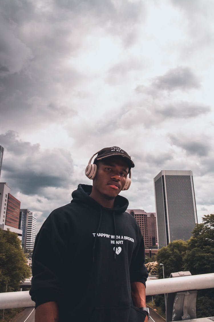 Trendy Black Man In Headset Under Cloudy Sky