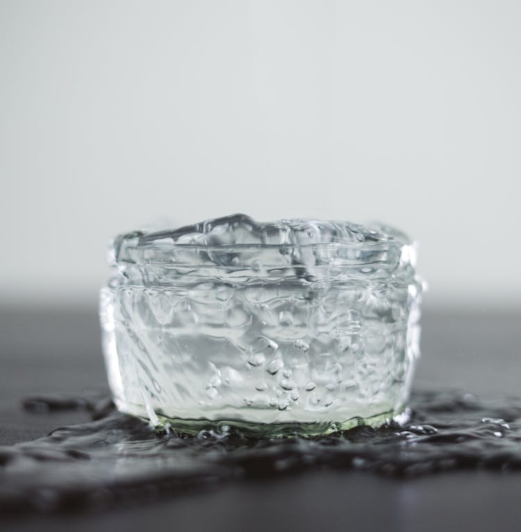 Ice Cubes In Transparent Jar On Wet Surface