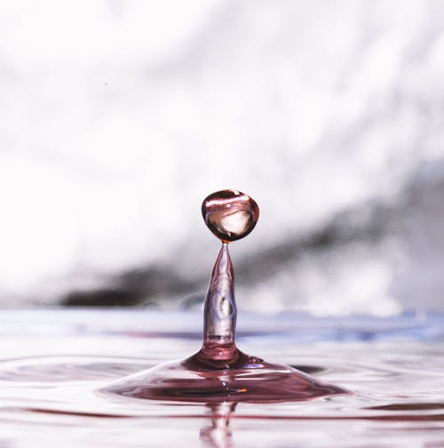 Crystal drop reflecting on glowing rippled water