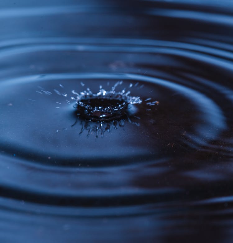 Dynamic Splash On Blue Water With Ripples