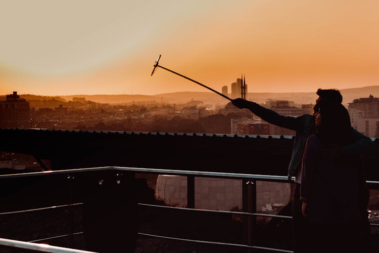 Couple Taking Selfie On Mobile Phone On Rooftop