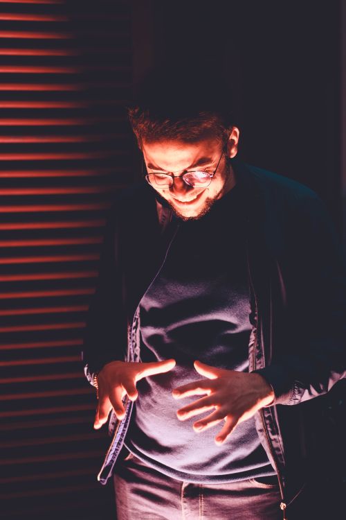 Free A man smiling warmly, illuminated by vibrant indoor lighting. Stock Photo