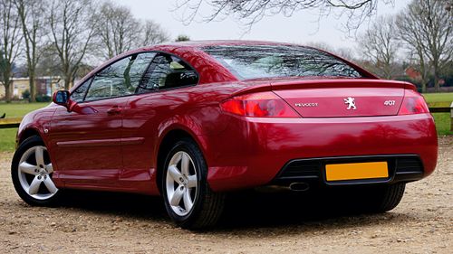 Free A luxurious red Peugeot 407 coupe parked outdoors in a scenic UK landscape. Perfect for auto enthusiasts. Stock Photo
