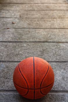 From above of orange basketball ball placed on ground on street on sunny day