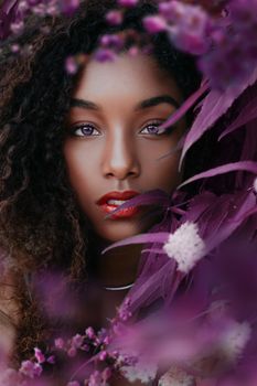 Captivating close-up portrait of a woman with vibrant purple flowers accentuating her beauty.