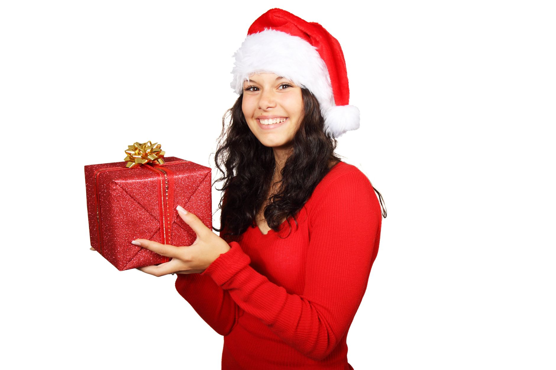 Happy young woman in a Santa hat holding a gift, symbolizing Christmas joy and spirit.