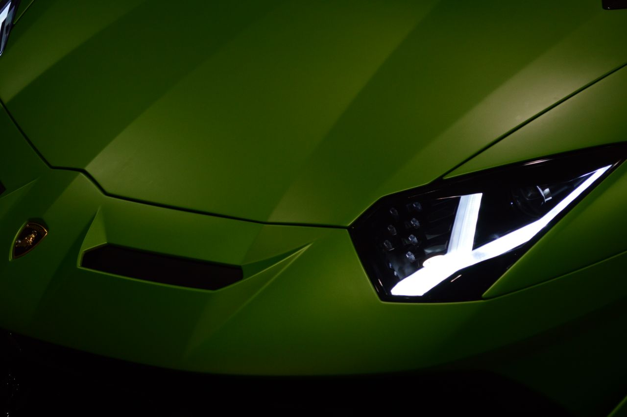 close up view of a green lamborghini showcasing its sleek design and v