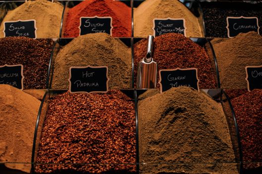 Overhead view of dry multi colored set of seasoning in lidless transparent boxes in marketplace