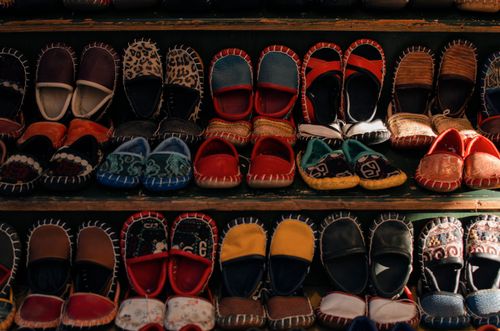 Free Shelves with assorted small bright handmade Turkish boots for kids selling in small local workshop Stock Photo