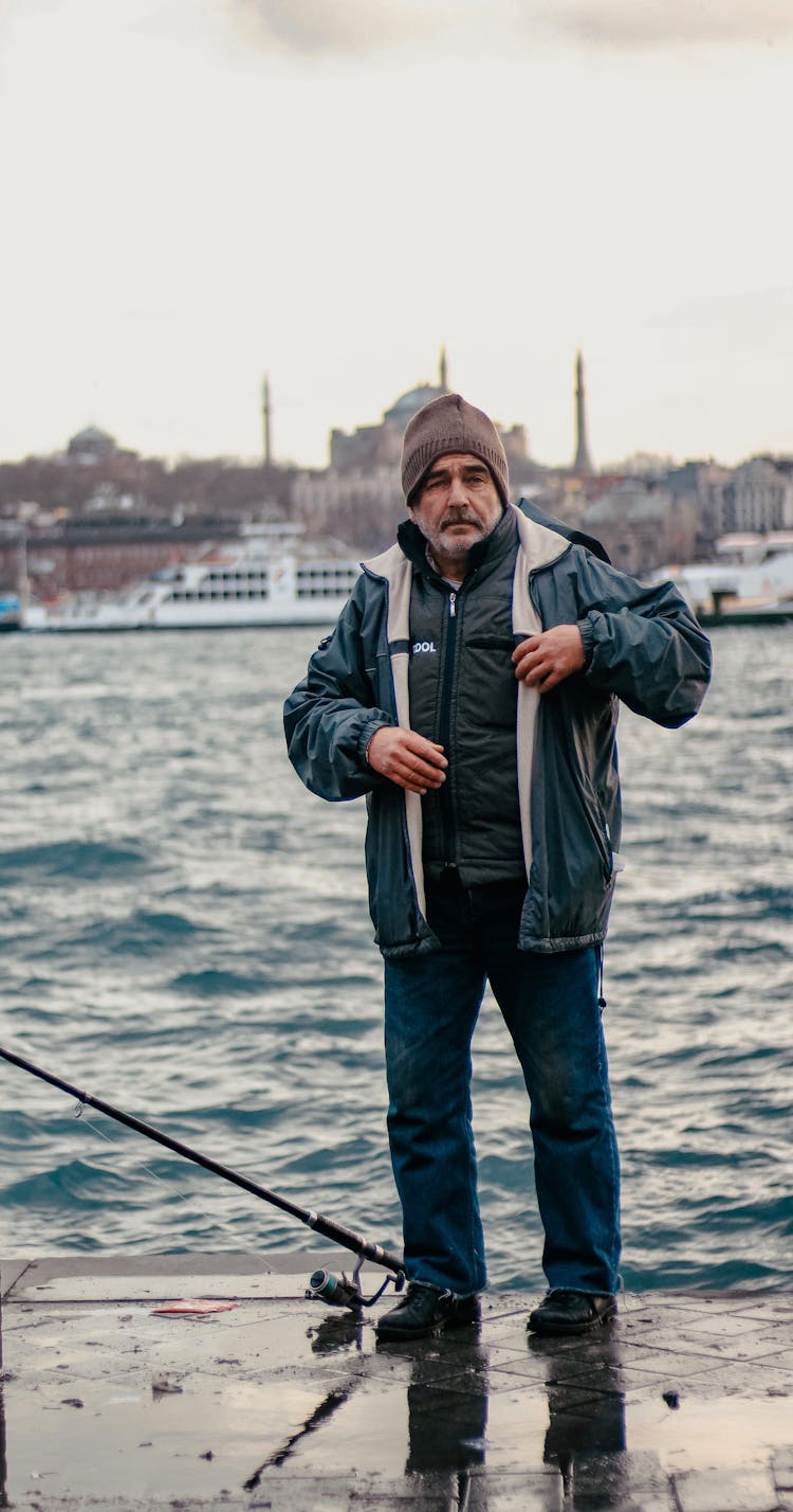 Serious Senior Fisherman Standing By River