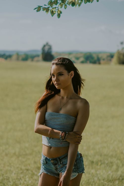 Free Calm young female in summer outfit standing in field in countryside and thinking while looking away Stock Photo