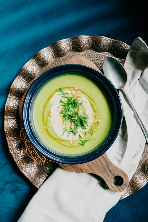 Plate with delicious vichyssoise cream soup served on table with blue tablecloth