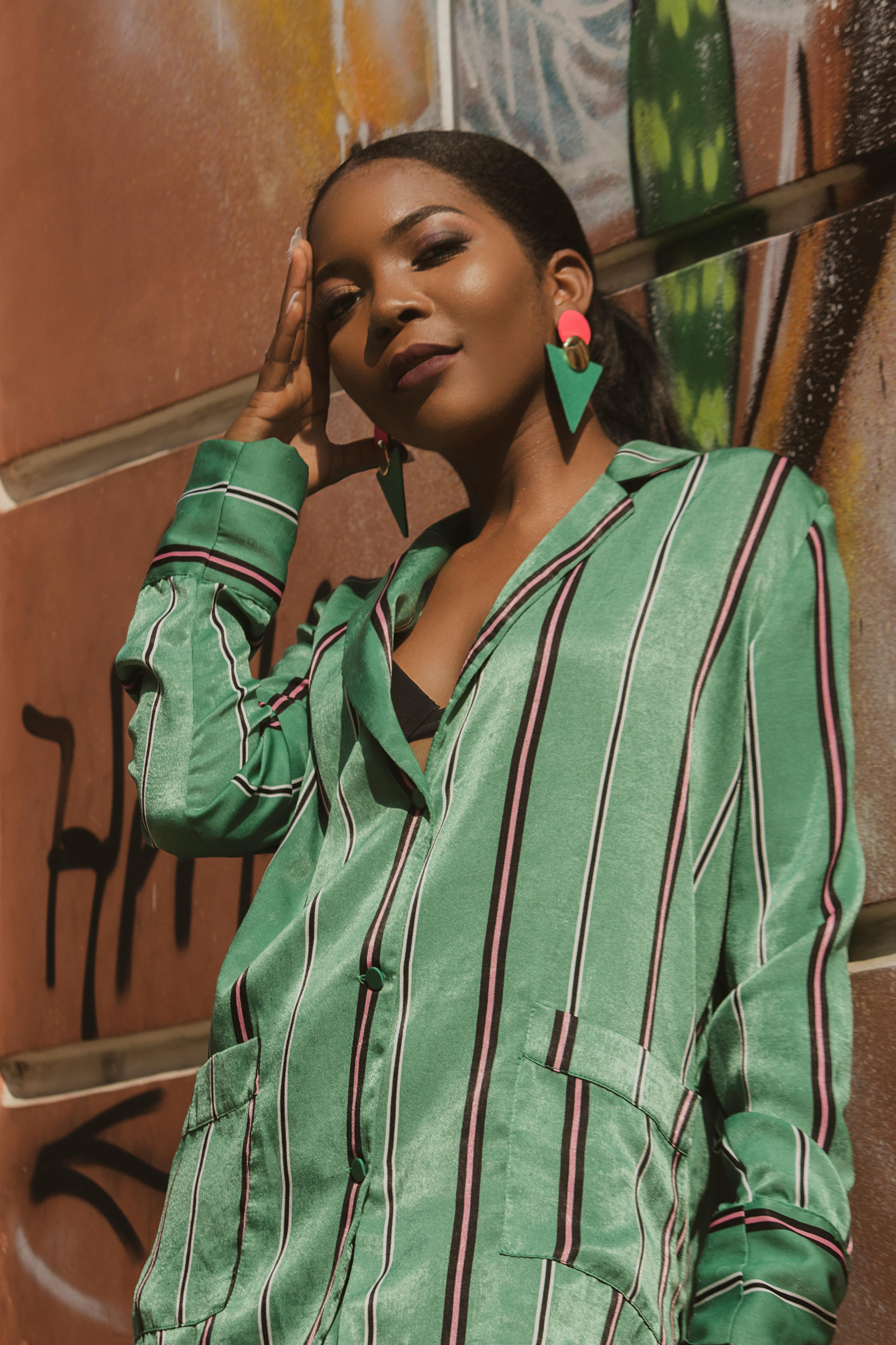 woman in green and white stripe long sleeve shirt holding black and white tumbler