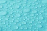 微距拍摄捕捉了水滴在充满活力的绿松石表面的纹理与清晰度