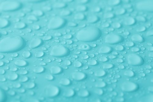 Free Macro shot of water droplets on a vibrant turquoise surface, showcasing texture and clarity. Stock Photo