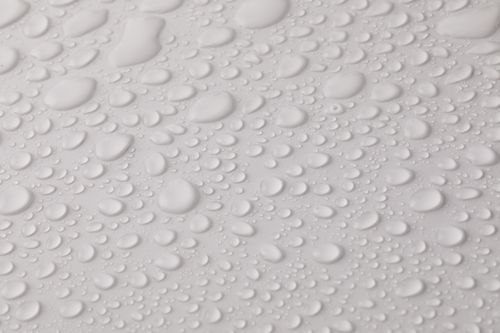 Free Closeup top view of plain wet abstract surface with small dripped water drops of different shapes placed on white background Stock Photo