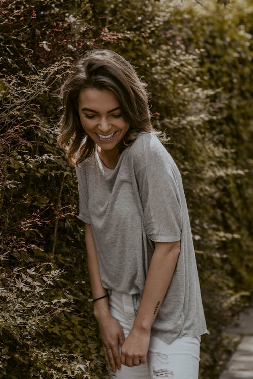 Young smiling woman standing near tree branches