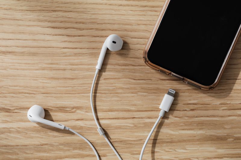Căști wireless așezate lângă un smartphone pe birou