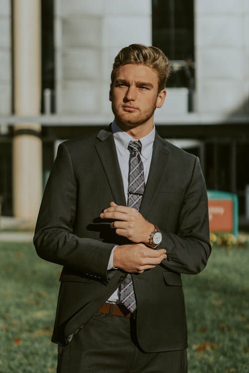 Successful businessman in elegant suit standing on street