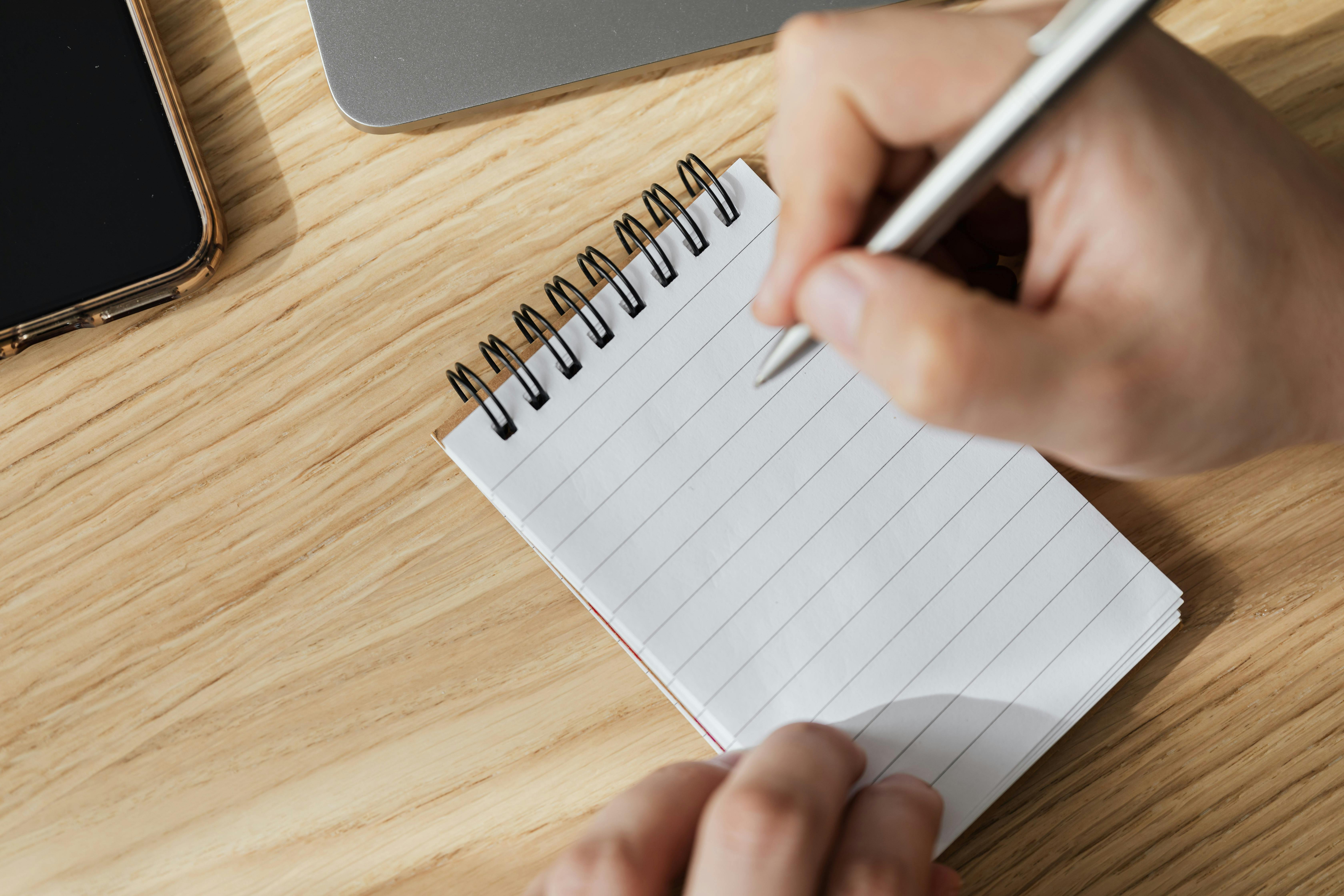 crop man with pen and opened notebook