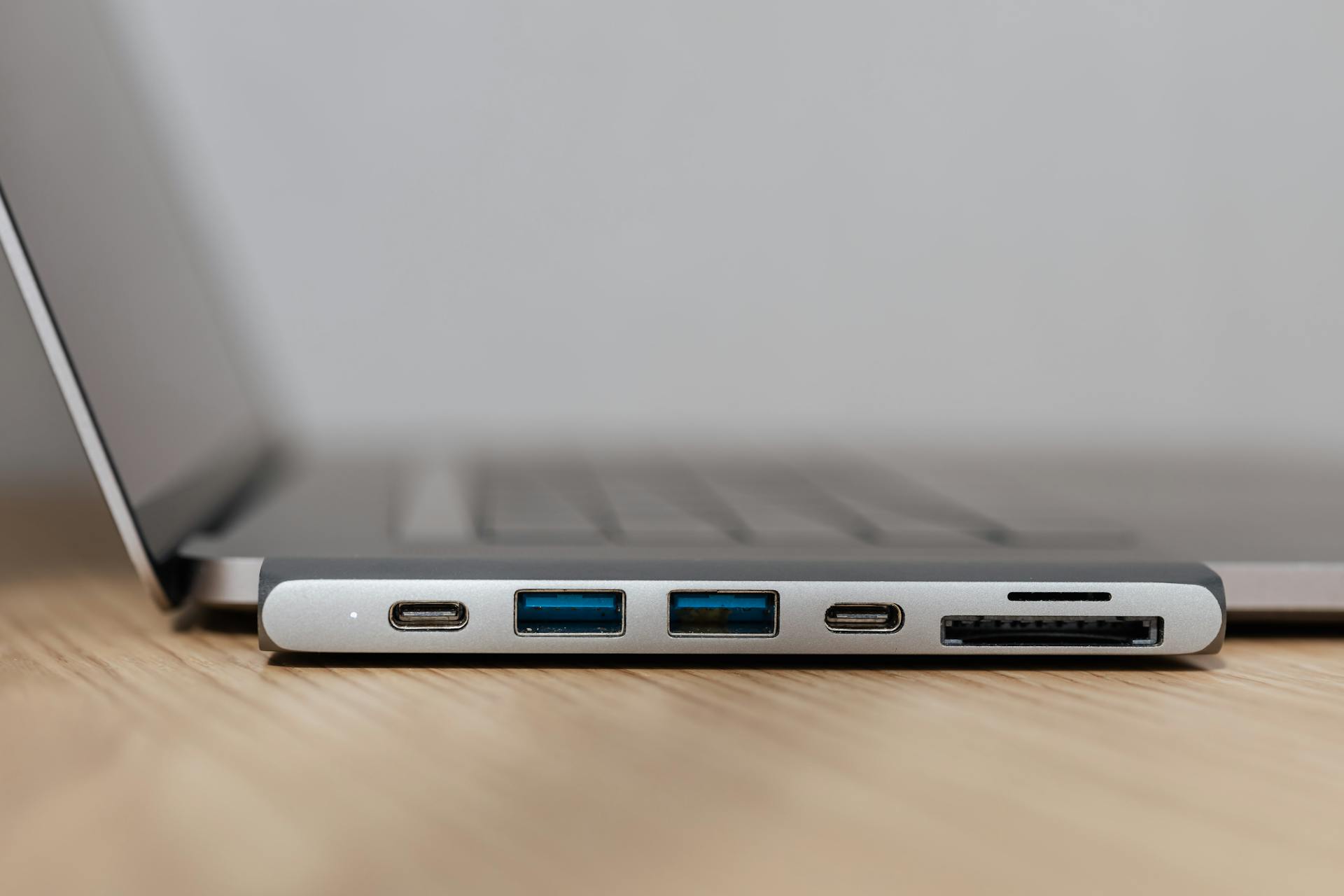 Space grey type c USB hub with multiple different ports connected to laptop