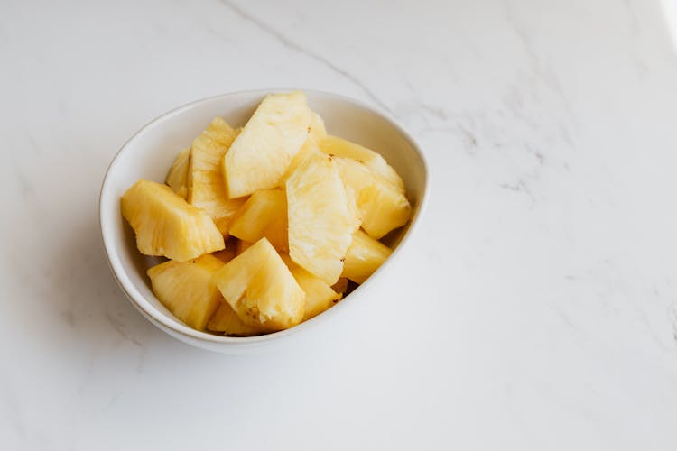 Healthy Sliced Pineapple In White Bowl