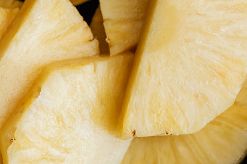 Top view closeup background of yellow ripe fresh sliced pineapple placed on top of each other