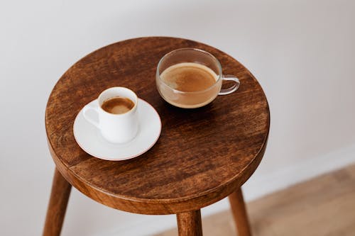 Tasty black coffee in different cups on small table