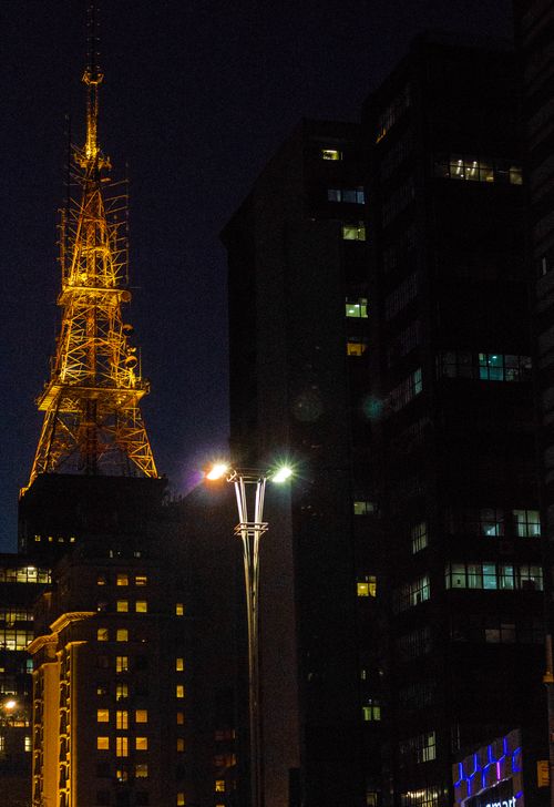 Free Brightly lit tower and city buildings create a stunning night scene. Stock Photo