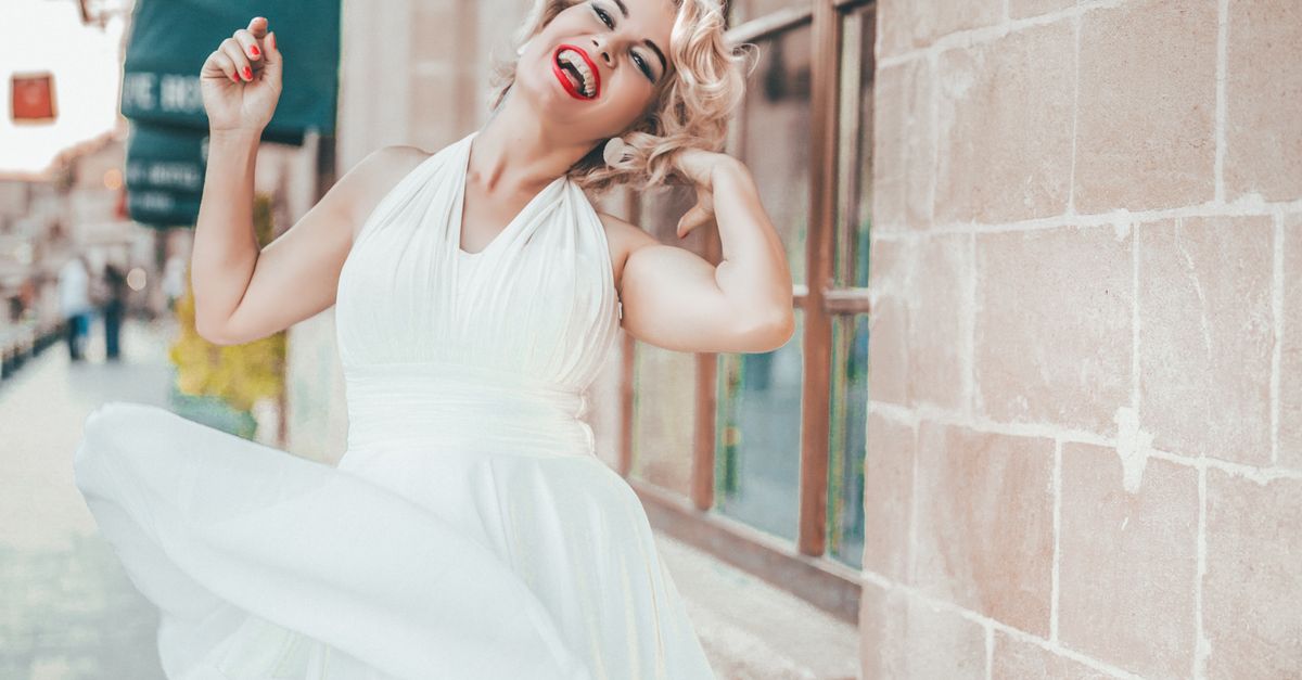 Mujer caucásica elegante en un vestido blanco posando alegremente al aire libre en Estambul. Mujer caucásica elegante en un vestido blanco posando alegremente al aire libre en Estambul.