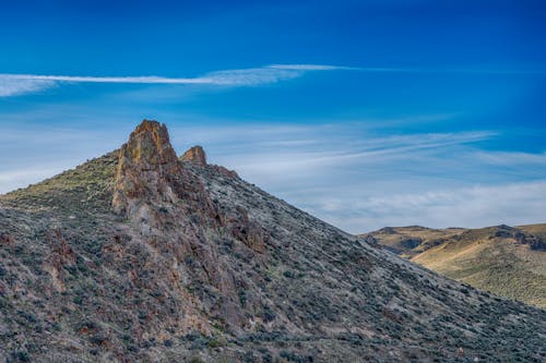 High rough mountain with moss under bright sky