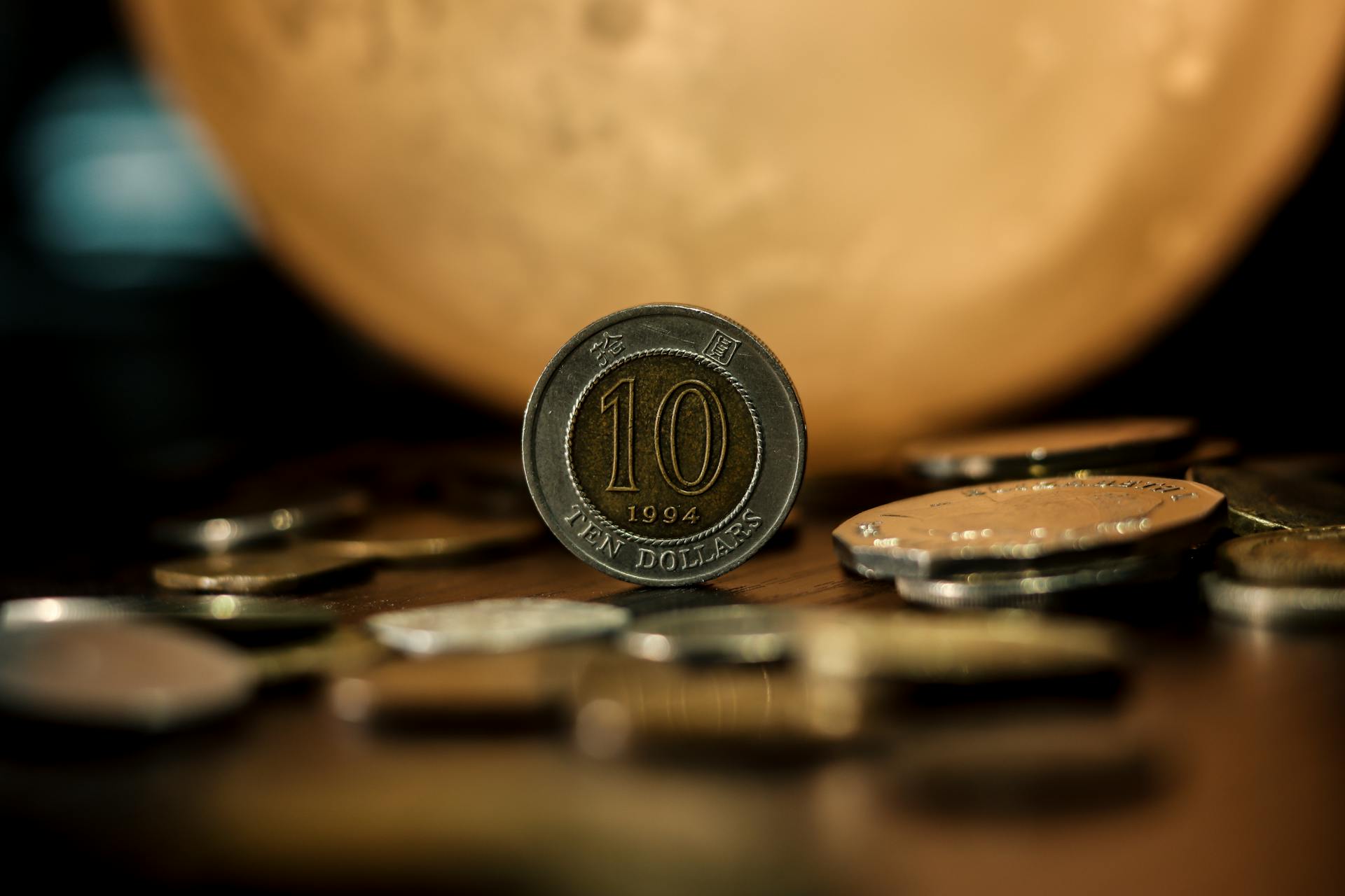 Detailed close-up of a ten dollar coin with a blurred golden background, highlighting currency and finance.