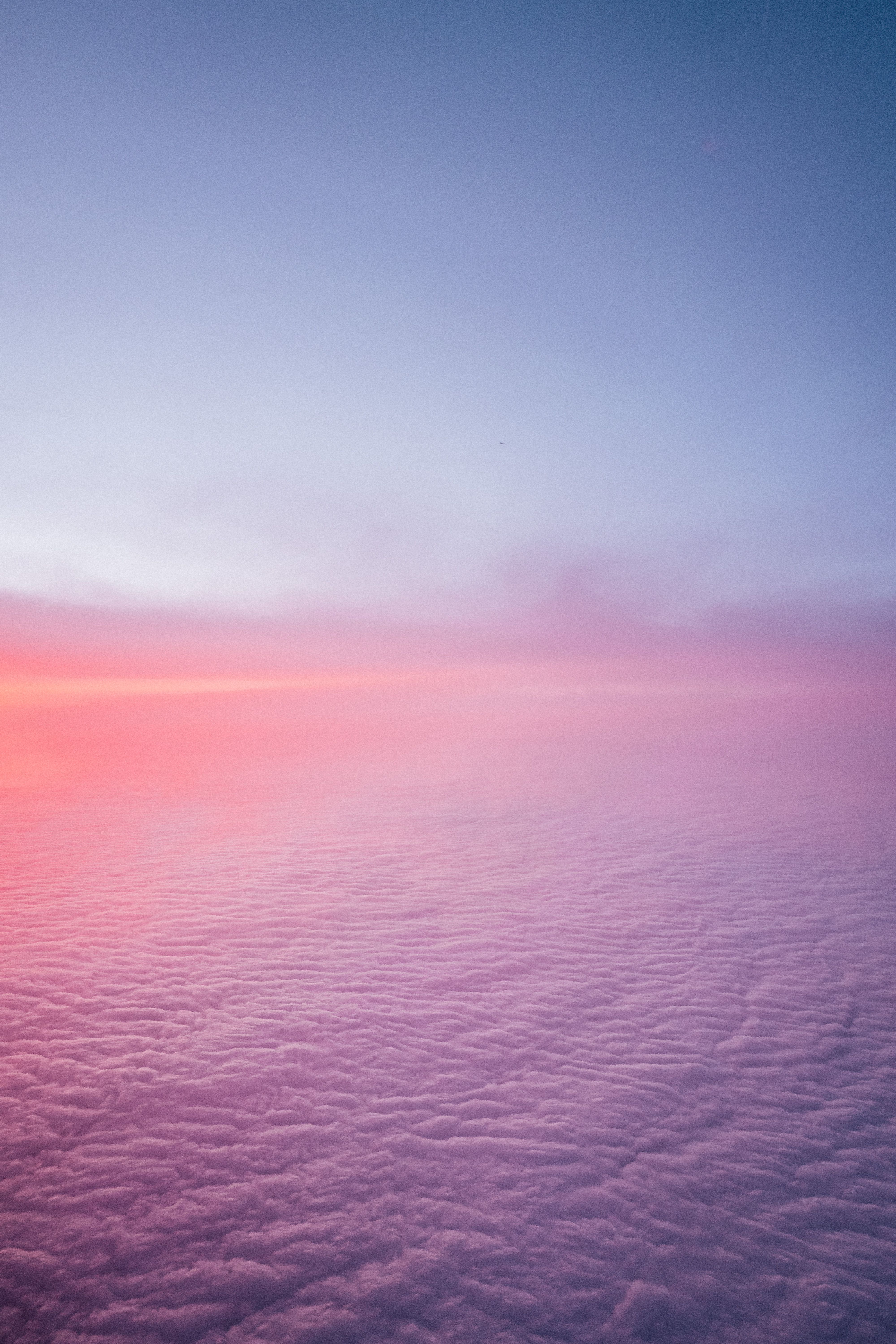Magical aerial view showcasing a tranquil landscape of pink and blue clouds during sunset, perfect for nature lovers.