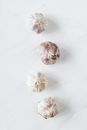 Top view of fresh raw aromatic unpeeled whole garlic bulbs arranged in zigzag line while placed on white marble background