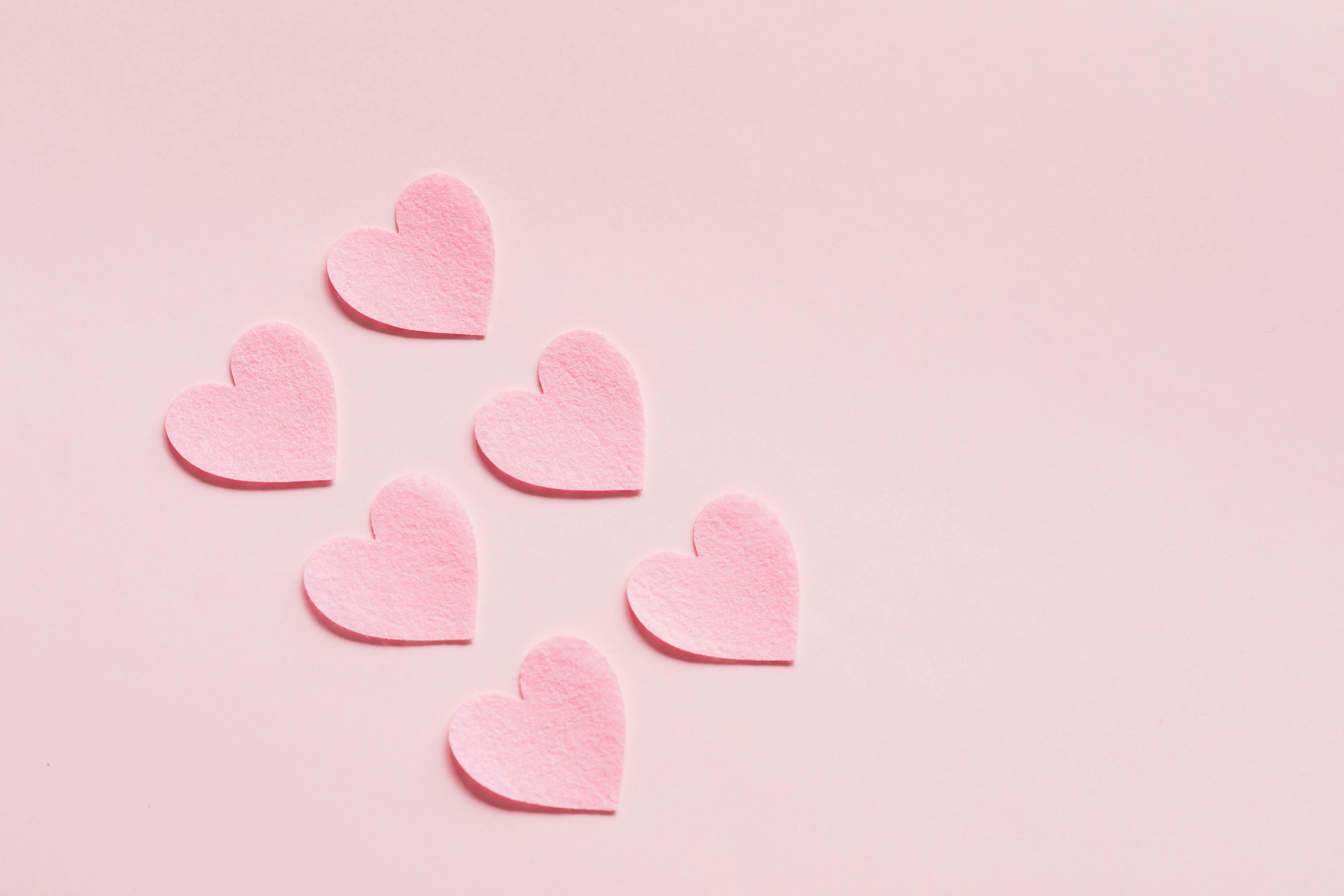 Heart shaped papers on pink background  Free Stock Photo
