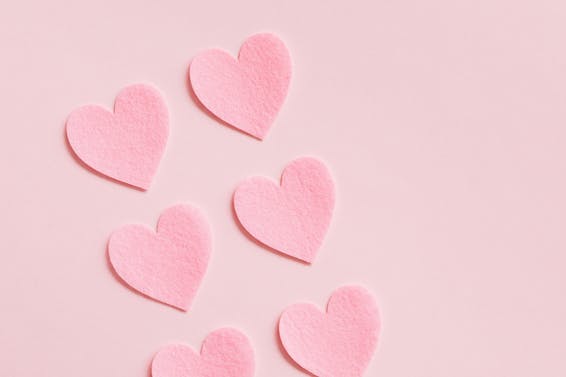 Heart Shaped Paper Cutouts On Pink Background