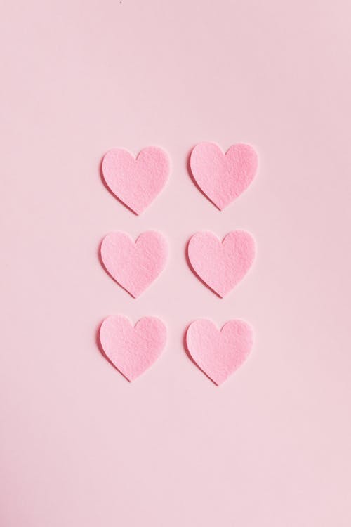 Heart Shaped Cutouts on Pink Background · Free Stock Photo