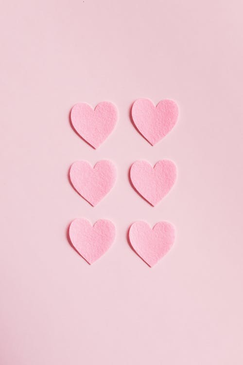 Free Heart Shaped Cutouts on Pink Background Stock Photo