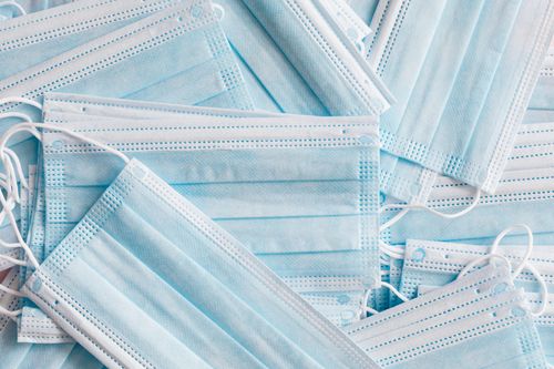 Free Top view of simple light blue medical protective face masks placed on top of another in disorder under bright light Stock Photo