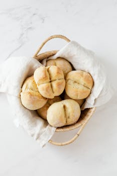 Delicious homemade bread rolls served in a wicker basket, perfect for any meal.