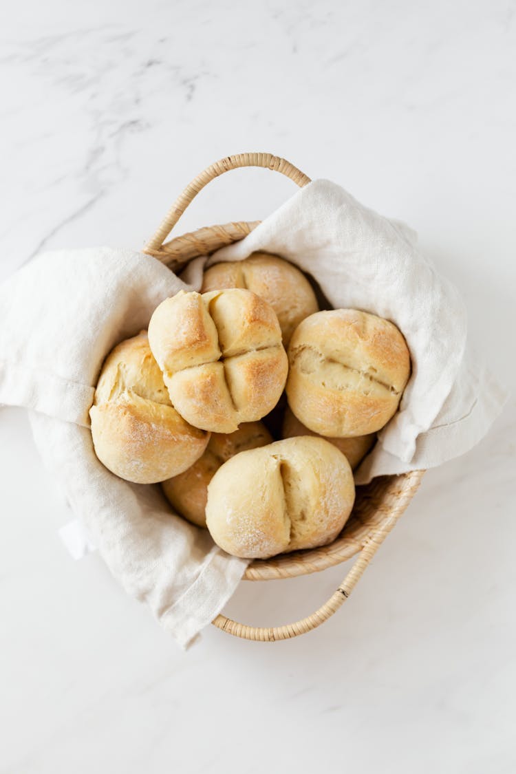 Basket With Fresh Swiss Buns On Marble Table