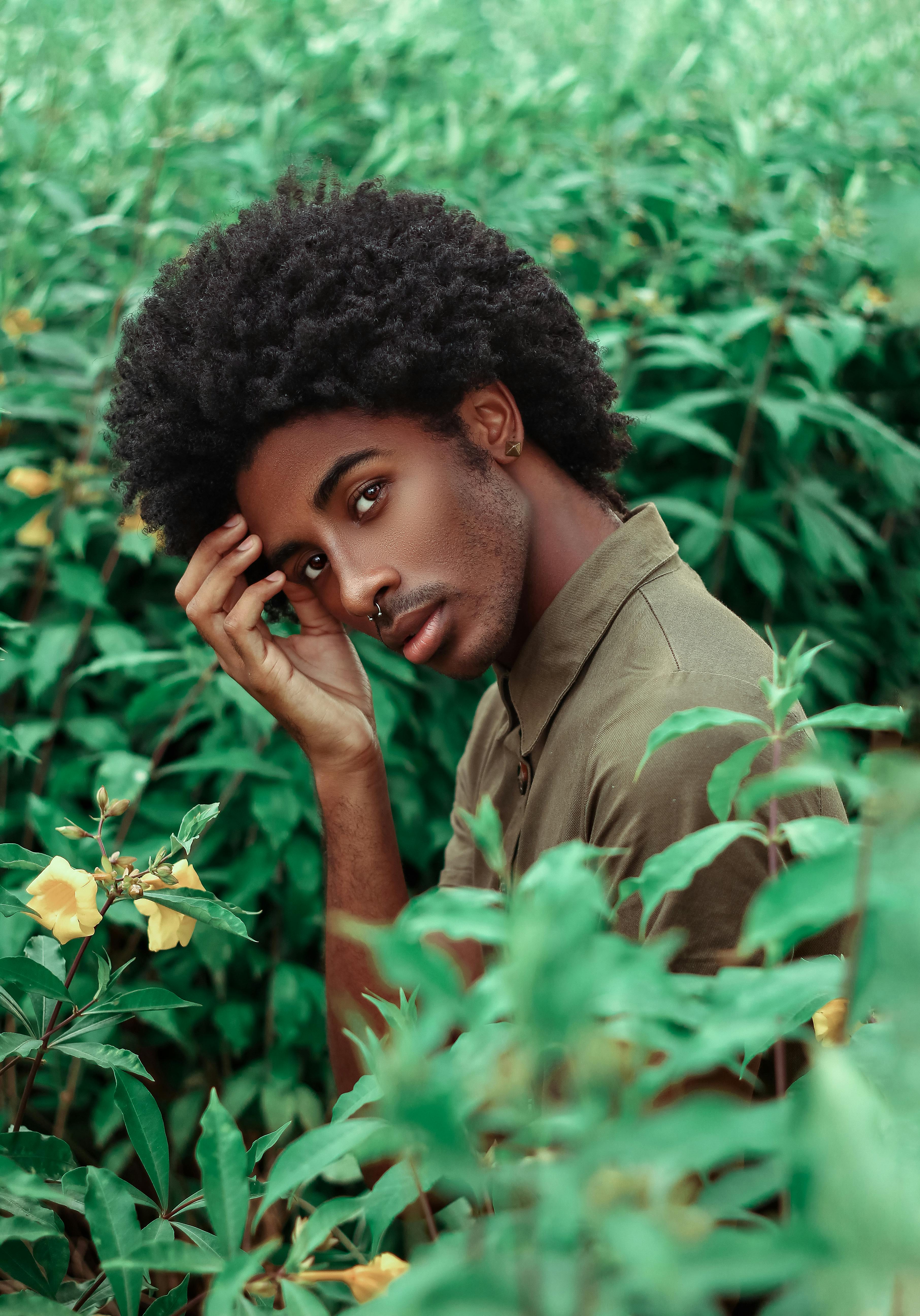 Stylish black man with Afro hairstyle on stones · Free Stock Photo