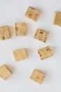 Top view of stock cubes in golden wrappers scattered on white marble table