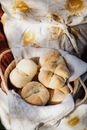 Crop female baker with fresh wheat buns on sunny day