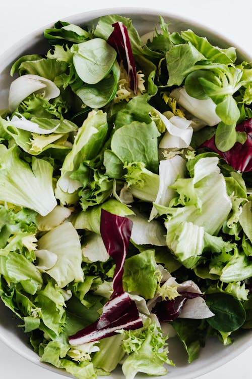 Free Top view of healthy lettuce and spinach salad served in white round bowl Stock Photo