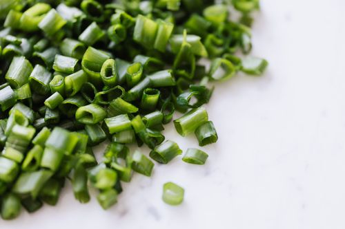 Free From above of fresh spring chopped green onion scattered on white marble table Stock Photo