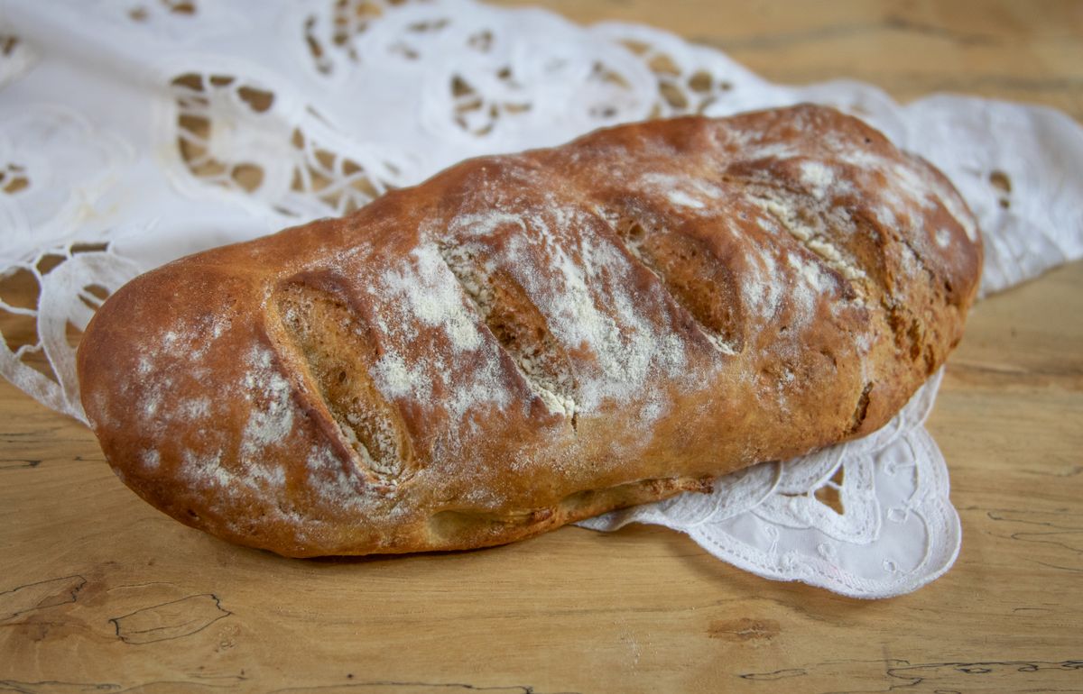 Scored country loaf resting on a linen cloth — photo by Magda Ehlers on Pexels
