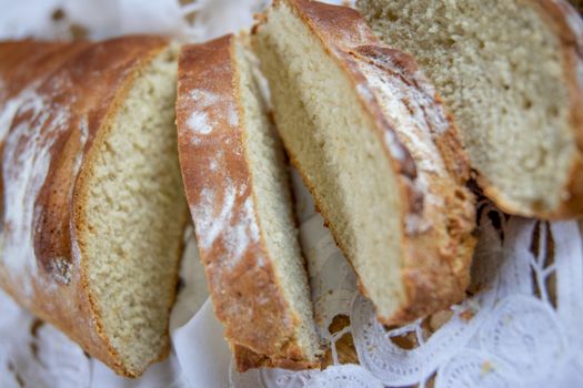 Close-up of freshly baked sliced bread displayed on a lace cloth, highlighting texture.